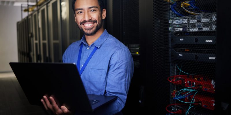 Automatisierung & KI in der IT-Infrastruktur IT-Spezialist mit Laptop im Serverraum – Symbol für Künstliche Intelligenz und Automatisierung moderner IT-Prozesse.
